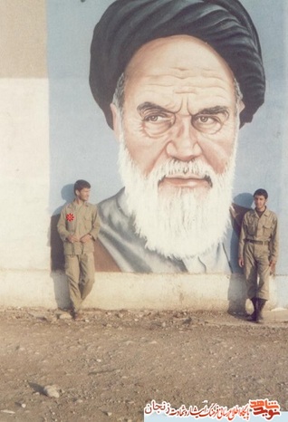 شهید حسن باقری در کنار تصویر امام 